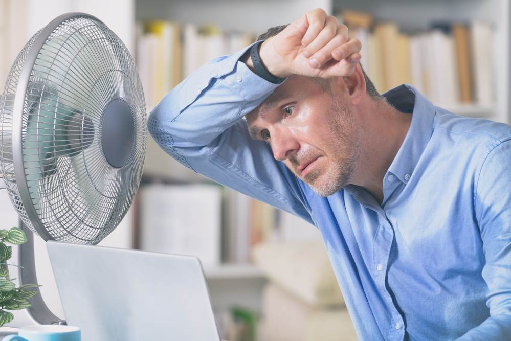 uncomfortable man in hot, stuffy room